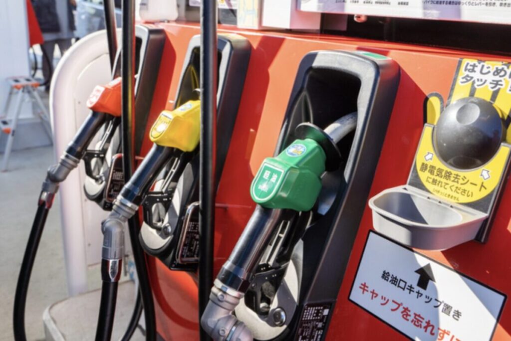 ガソリンスタンドの給油機に並ぶレギュラー・ハイオク・軽油の給油ノズル